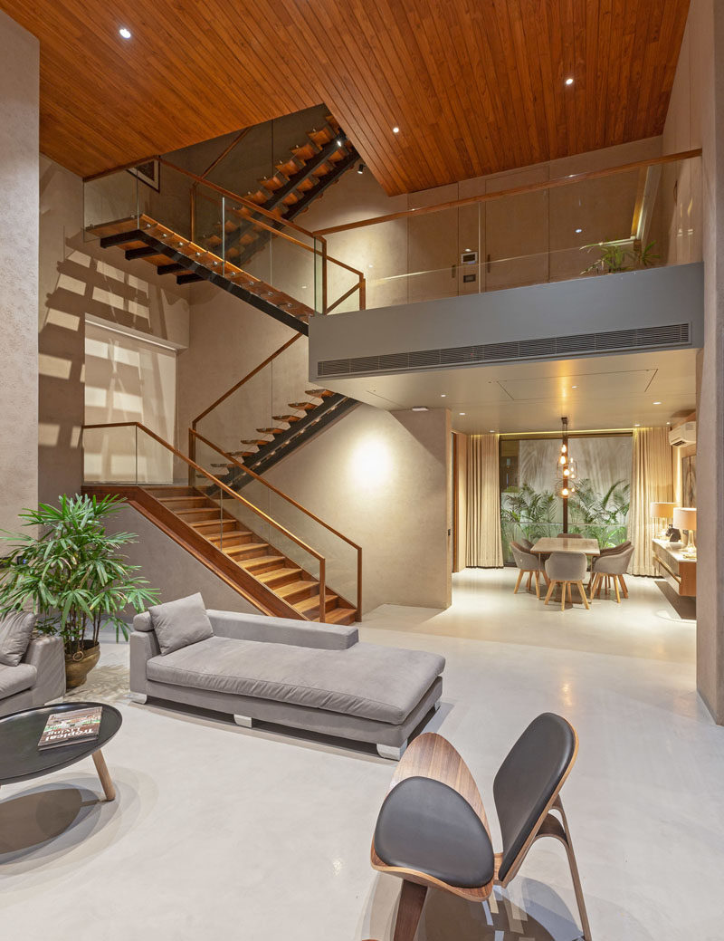 A large wood and steel staircase connects the various levels of this modern house, and leads the eye upwards to the wood ceiling. #ModernStairs #StairDesign