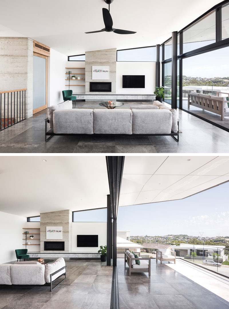 This modern living room, which features a fireplace, seamlessly transitions to the outdoor balcony via a huge expanse of glass and oversize sliding doors. #LivingRoom #Fireplace #Balcony