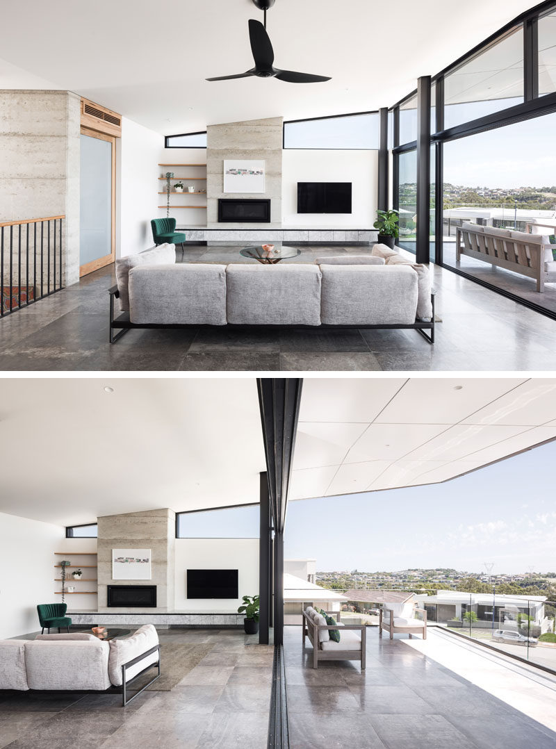This modern living room, which features a fireplace, seamlessly transitions to the outdoor balcony via a huge expanse of glass and oversize sliding doors. #LivingRoom #Fireplace #Balcony