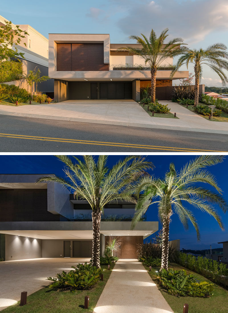 At the front of this modern house, landscaping with strategically placed lighting, highlights the driveway and the path to the front door. #Landscaping #OutdoorLighting #ModernHouse