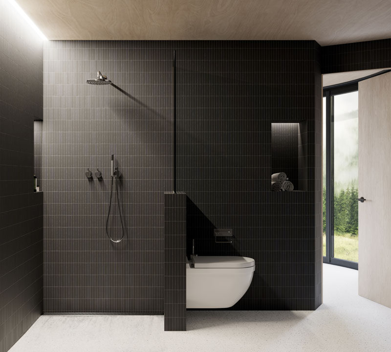 This modern bathroom has dark tiles that contrast the wood ceiling, while hidden lighting helps to keep the small space bright. #ModernBathroom #BathroomDesign