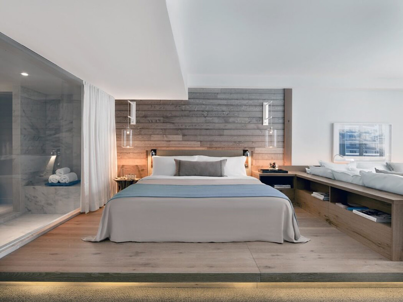 BEDROOM IDEAS - This modern bedroom has a raised sleeping area with hidden lighting, and a wood accent wall behind the bed to match the wood floor. #BedroomIdeas #MasterBedroomIdeas #BedroomDesignIdeas