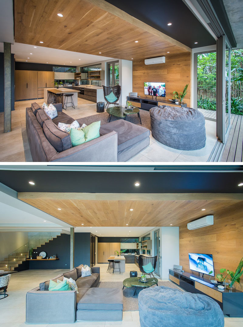 Wood elements, like the wood ceiling that wraps around and down onto the wall in the living room, bring a natural touch to the interior of this modern house. #WoodCeiling #WoodAccent #ModernInterior #ModernHouse #LivingRoom