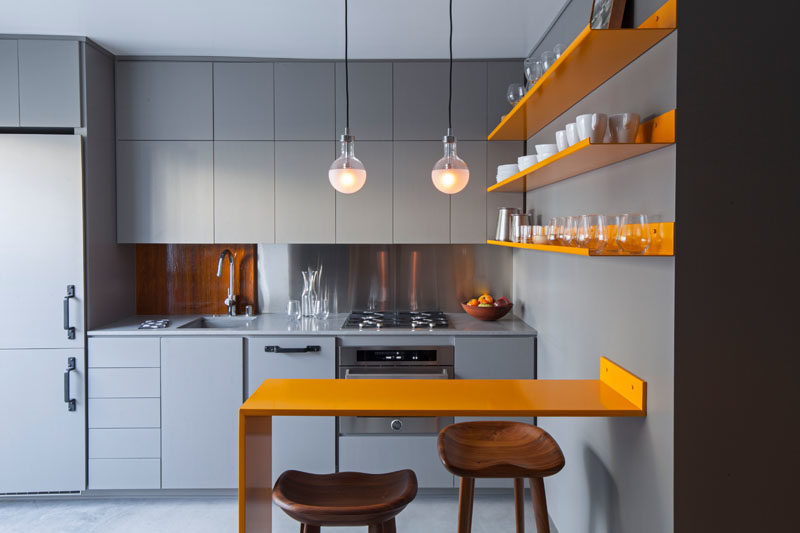 Kitchen Ideas - Stepping inside this modern micro apartment, and the kitchen cabinetry, countertops, and concrete floor exactly match in color, achieved with an integral additive color for the concrete. #GreyAndYellow #SmallKitchen #KitchenDesign #KitchenIdeas
