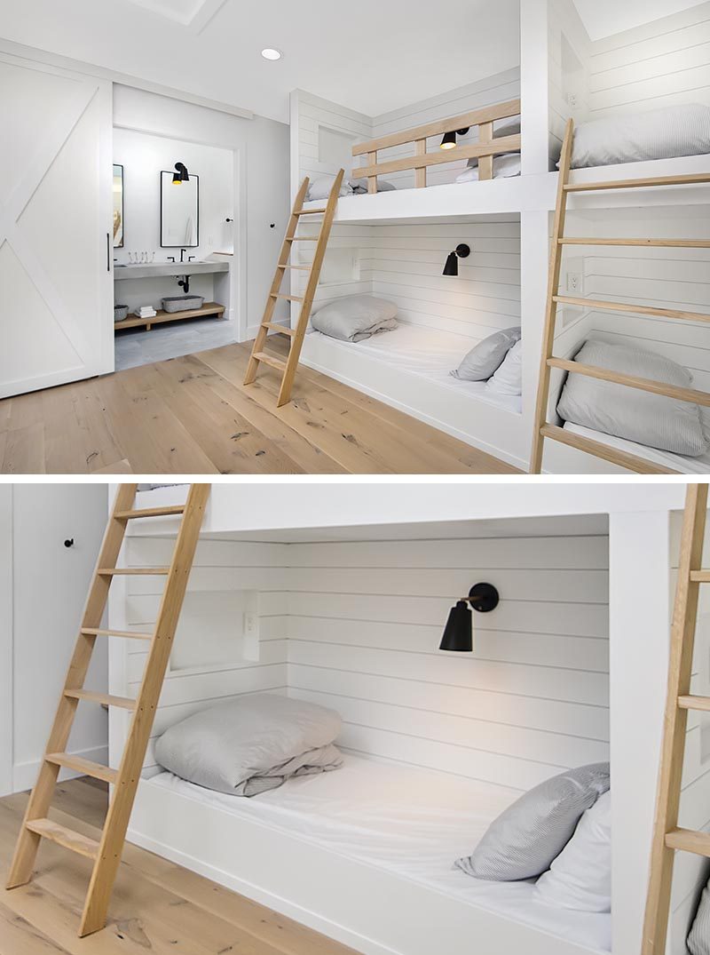 In this modern bedroom, three sets of built-in bunk beds with wood ladders and safety rails, create a place for six people to sleep. Each bunk has a niche, outlets and an individual switch for their separate light. #Bedroom #BunkBeds #MultipleBunkBeds #ModernBedroom