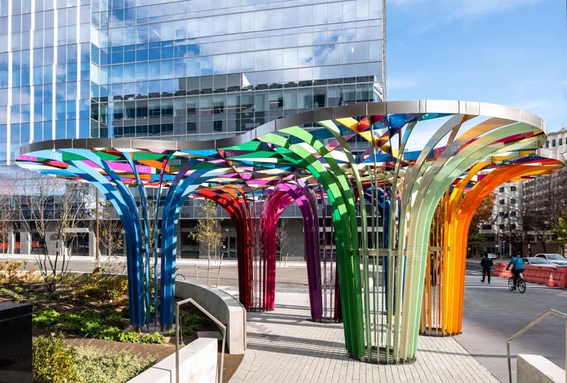 This modern public art installation invites visitors to walk through a grove of archways that have been woven together from intersecting bands of powder-coated aluminum in 28 colors. #PublicArt #PublicInstallation #PublicSculpture #ModernArt #ModernSculpture #Design