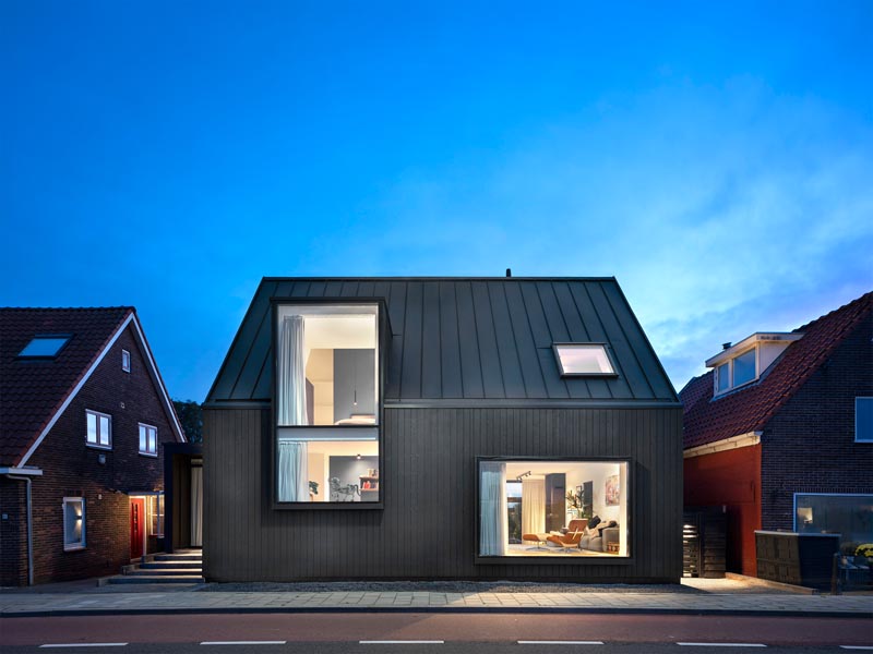 The exterior of this modern house features black wooden ventilated facade in combination with a black metal roof. #BlackHouse #ModernBlackHouse #Architecture