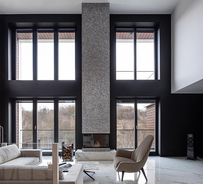 Sergey Makhno Architects recently completed a new house, and as part of the living room, they created a modern fireplace surround made from metal lace. #ModernFireplace #MetalFireplace #LivingRoom #MetalFireplaceSurround #Interiors #FireplaceDesign