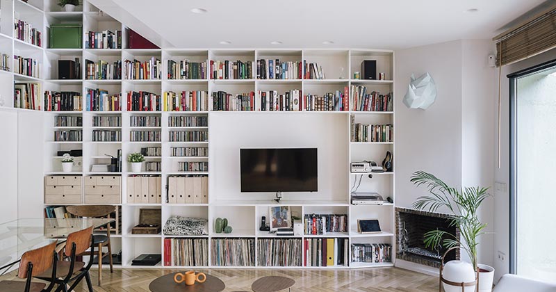 A Double-Height Bookshelf Travels Over Two Floors Of This House