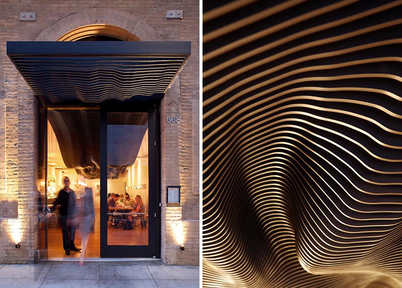 The striking black undulating sculptural detail travels from the interior of the restaurant out to the facade, where it covers the entryway and adds a modern element to the historic building. #BuildingFacade #SculpturalFacade #RestaurantDesign