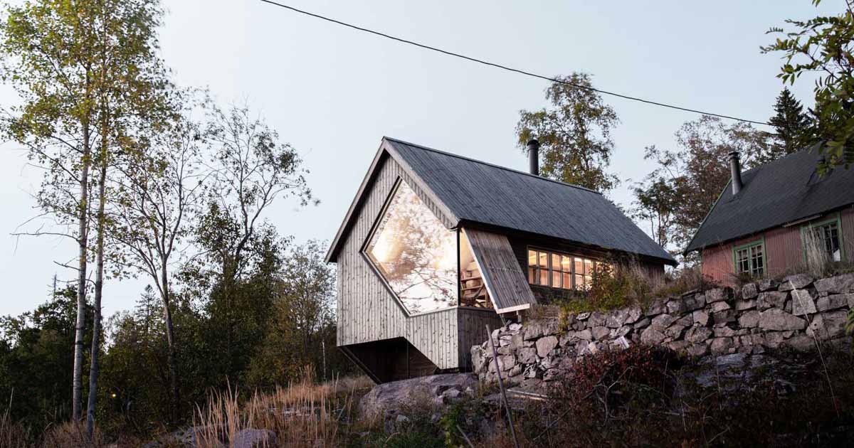 A Unique Window Shape Helps Frame The View From Inside This Cabin