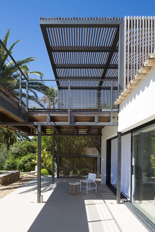 A pergola on the second floor of this home provides shade to the lower level.