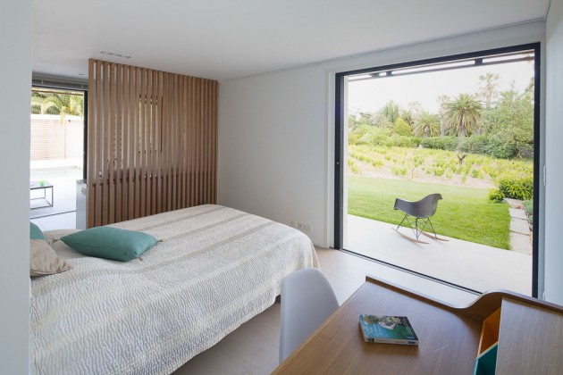 This bedroom has a large window with views of the backyard.