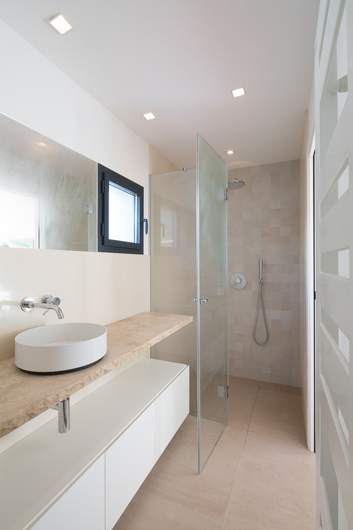 This bathroom has a vanity with a round sink.