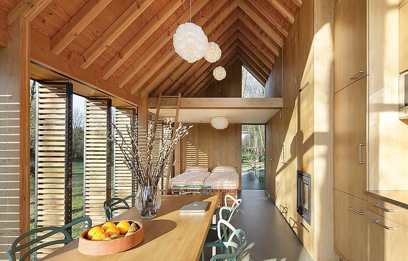 This modern open plan contemporary cottage has a wall of wood cabinets.