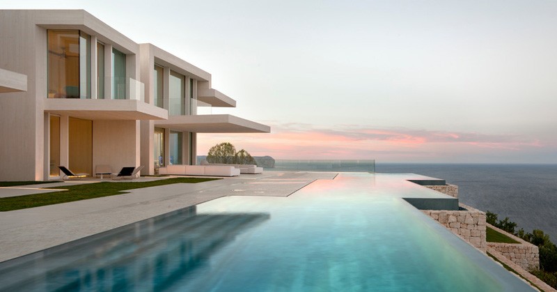 An infinity edge swimming pool seamlessly meets the deck that runs alongside it.