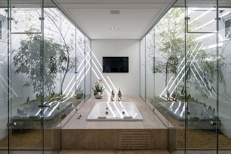 A Bathtub Surrounded By A Glass Enclosed Garden