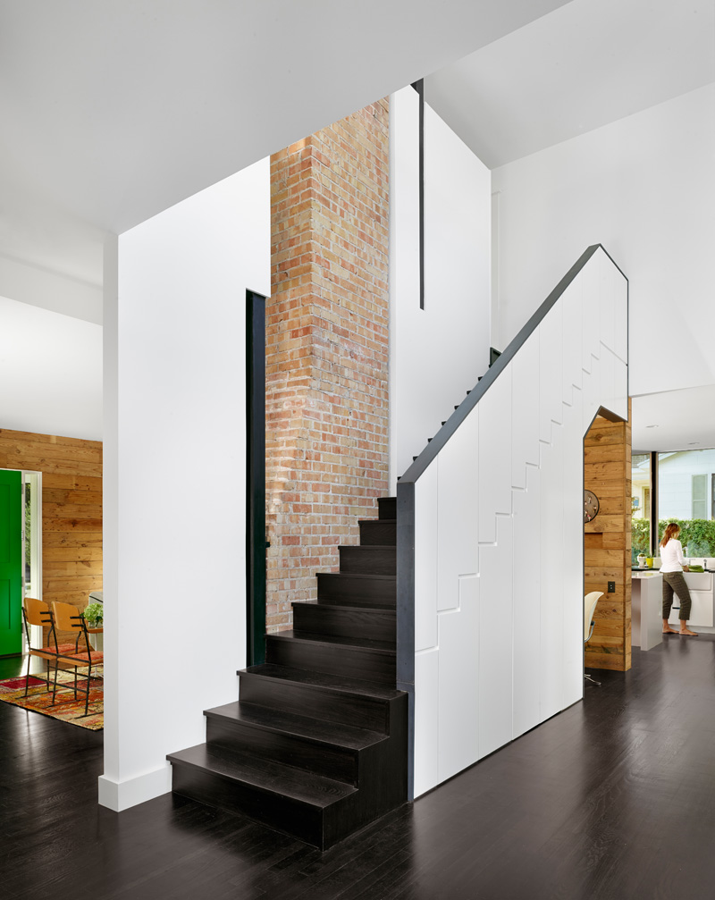 Dark wood stairs with a white exterior have have built-in hidden storage and an office nook.