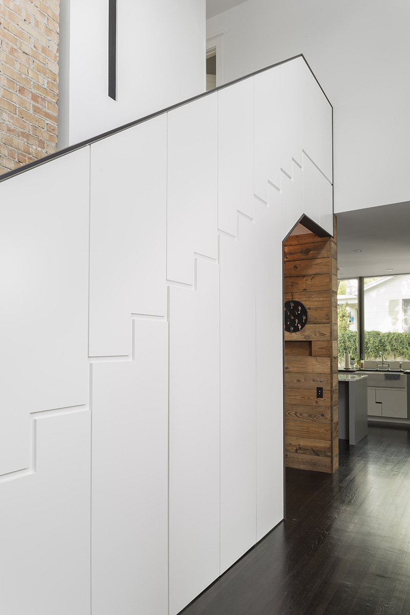 Hardware free cabinets under the stairs open to reveal storage of different sizes.