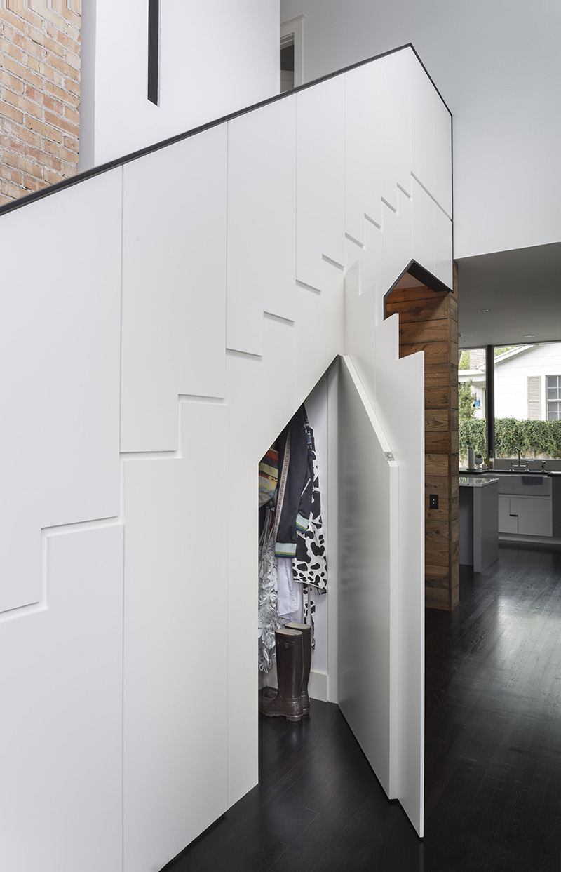 Hardware free cabinets under the stairs provide space for storing coats and shoes.