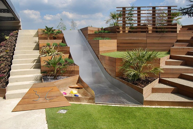 A Backyard Slide Among Terraced Planters