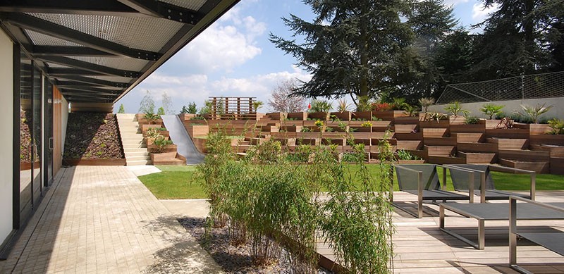 A Backyard Slide Among Terraced Planters