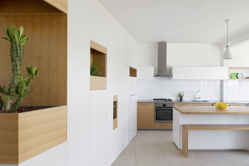 Pockets Of Plants Have Been Added To This White Wall Of Cabinets