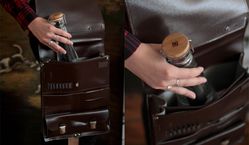 Glass water bottle with a wood cap and a charred bamboo filter.