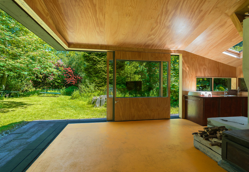 A small cabin with sliding doors that open the interior to the outdoors.