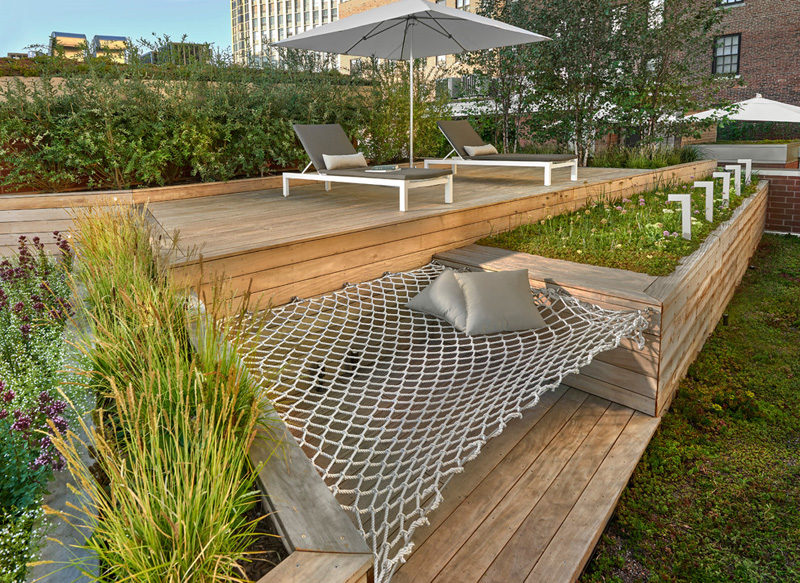 7 Design Lessons To Learn From This Awesome Roof Deck In Chicago // Build in furniture when you can -- Here you can see that instead of continuing the garden bed along the entire length, they decided to include an additional seating area, in the form of a built-in hammock.