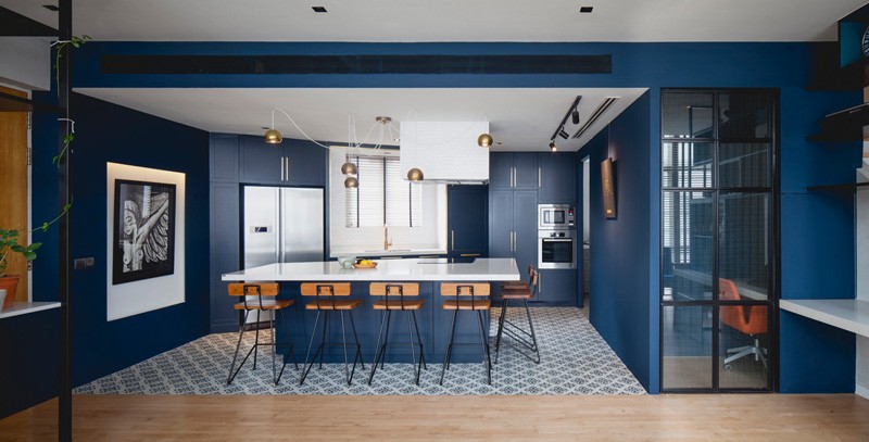 A modern apartment in Singapore with a bold royal blue kitchen. #BlueKitchen #ModernKitchen #BlueCabinets #InteriorDesign #KitchenDesign