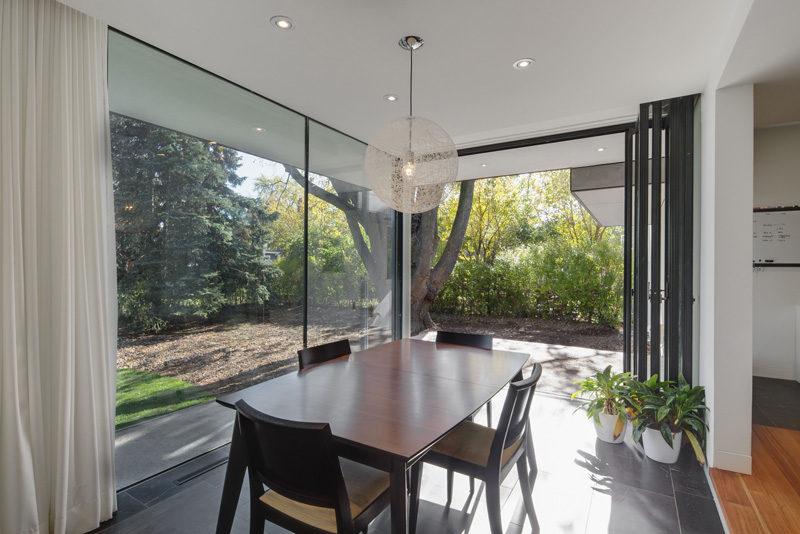 The backyard of this home is accessible through a wall of glass doors next to this dining room.