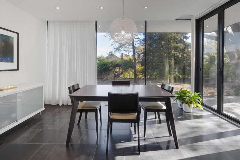 This dining room has view of the backyard through the floor-to-ceiling windows.