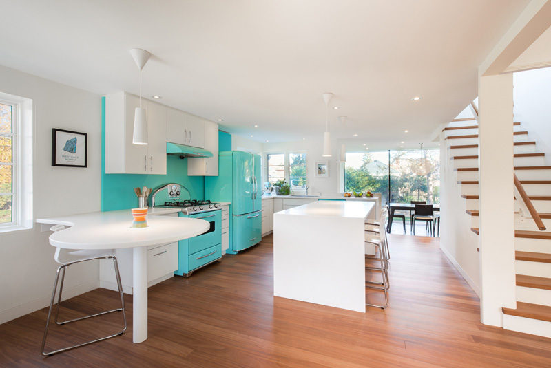 This bright retro turquoise of the kitchen really pops against the white cabinets and walls.