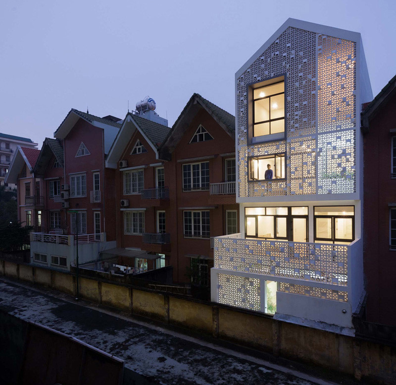 Landmak Architecture renovated a red brick row house in Vietnam, and to stand out from the rest, they surrounded the home with white concrete blocks. #RowHouse #WhiteConcrete #ConcreteBlocks #Architecture