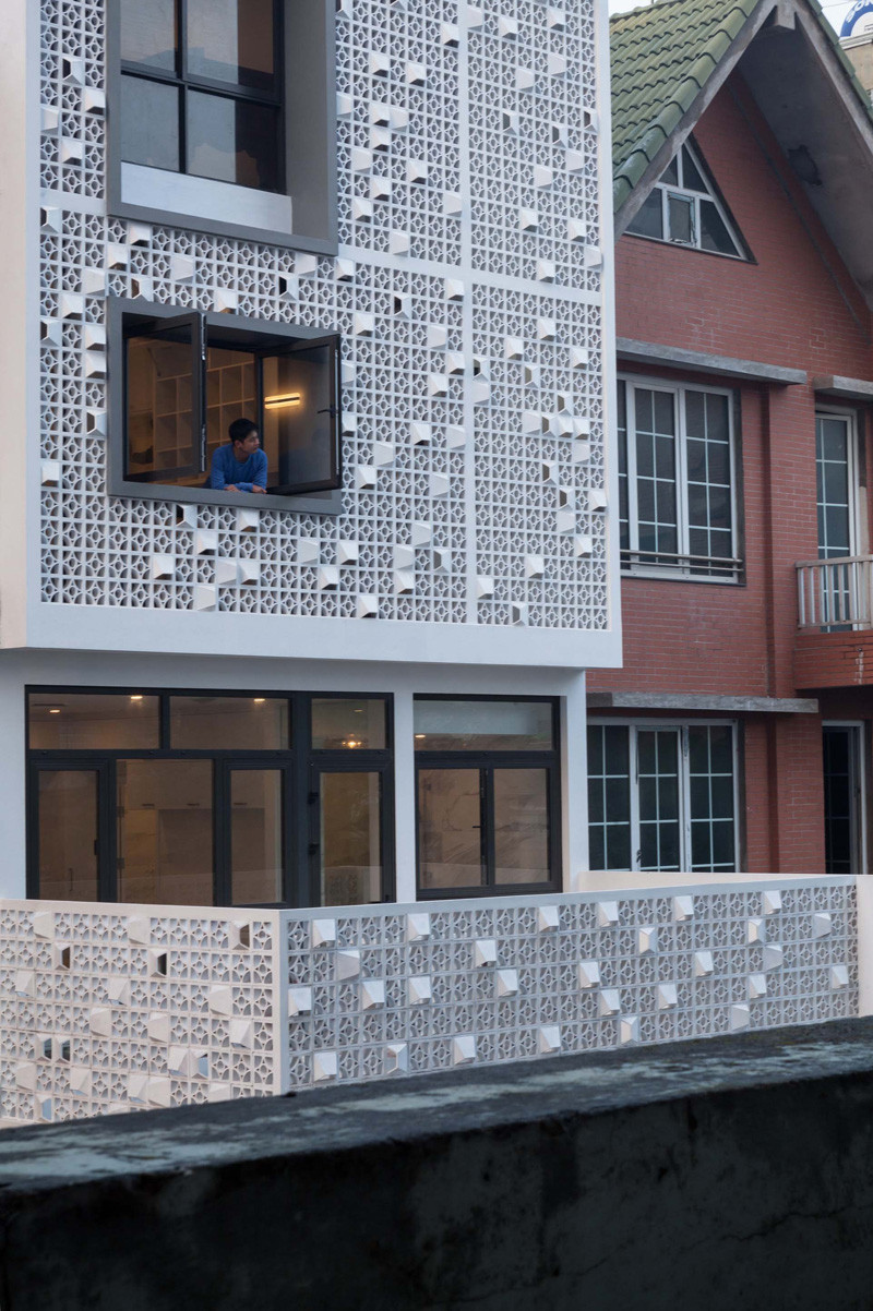 Landmak Architecture renovated a red brick row house in Vietnam, and to stand out from the rest, they surrounded the home with white concrete blocks. #RowHouse #WhiteConcrete #ConcreteBlocks #Architecture