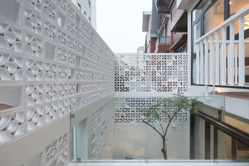 Landmak Architecture renovated a red brick row house in Vietnam, and to stand out from the rest, they surrounded the home with white concrete blocks. #RowHouse #WhiteConcrete #ConcreteBlocks #Architecture