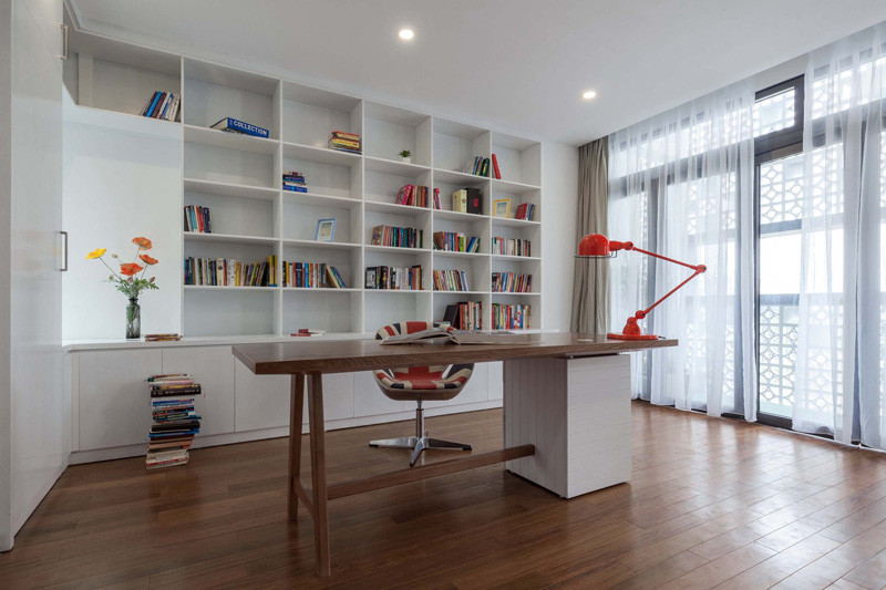 A modern home office with built-in shelving that lines the wall. #WhiteShelving #BuiltIShelving #Bookcase #WhiteBookshelf