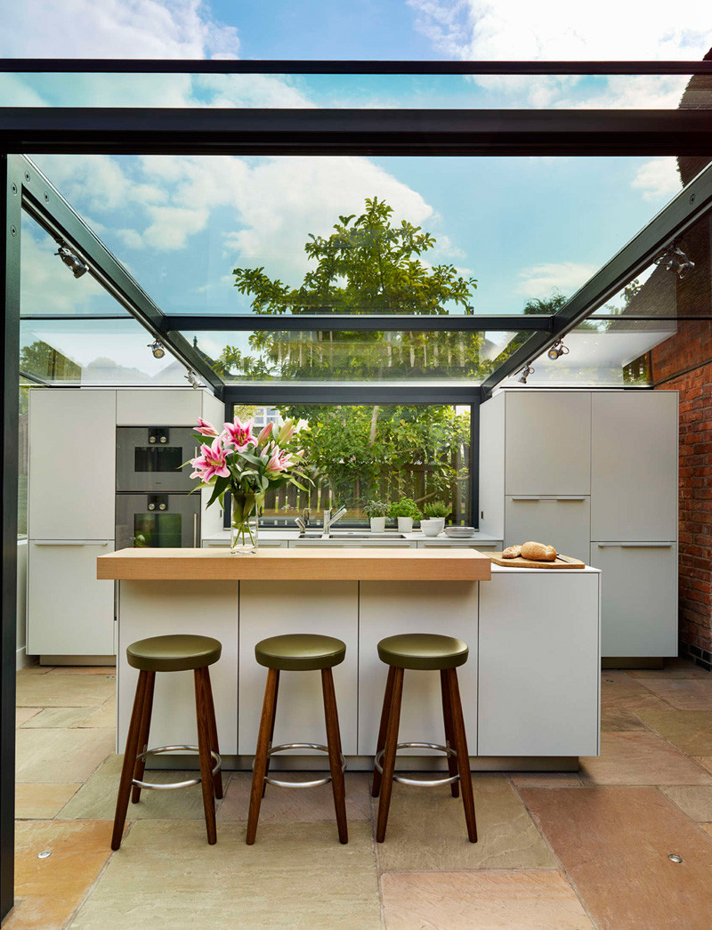 This thatched cottage got a glass box extension for the kitchen