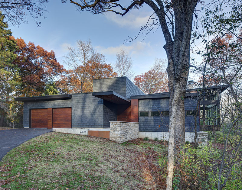 A new contemporary house in Wisconsin is covered in stone and shingles