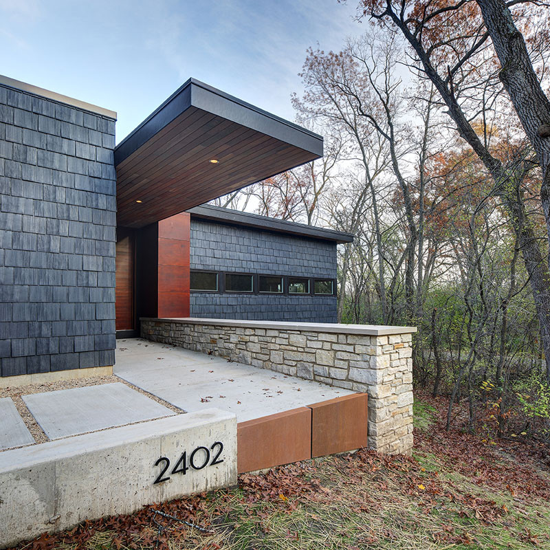 A new contemporary house in Wisconsin is covered in stone and shingles