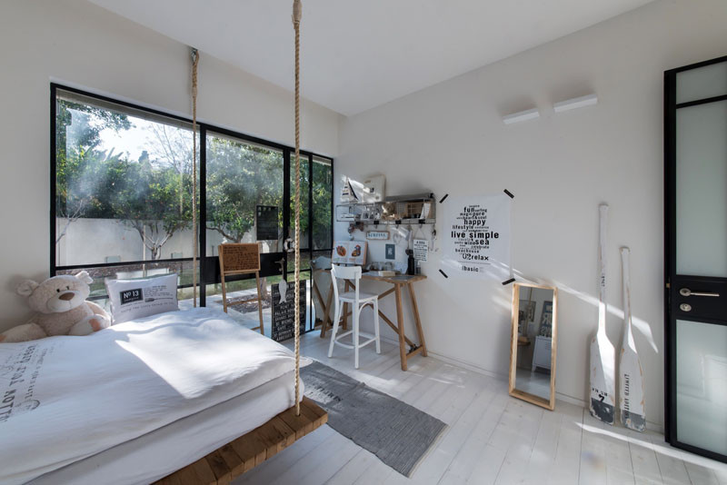 This hanging bed in a children's bedroom, is located inside a home in Tel Aviv, Israel, that has been designed by Neuman Hayner Architects.