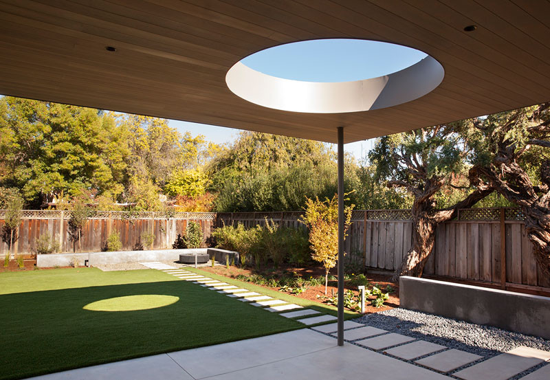 This modern backyard has a patio space with a path that leads you to the corner seating area. #ModernBackyard #YardIdeas #ModernPatio