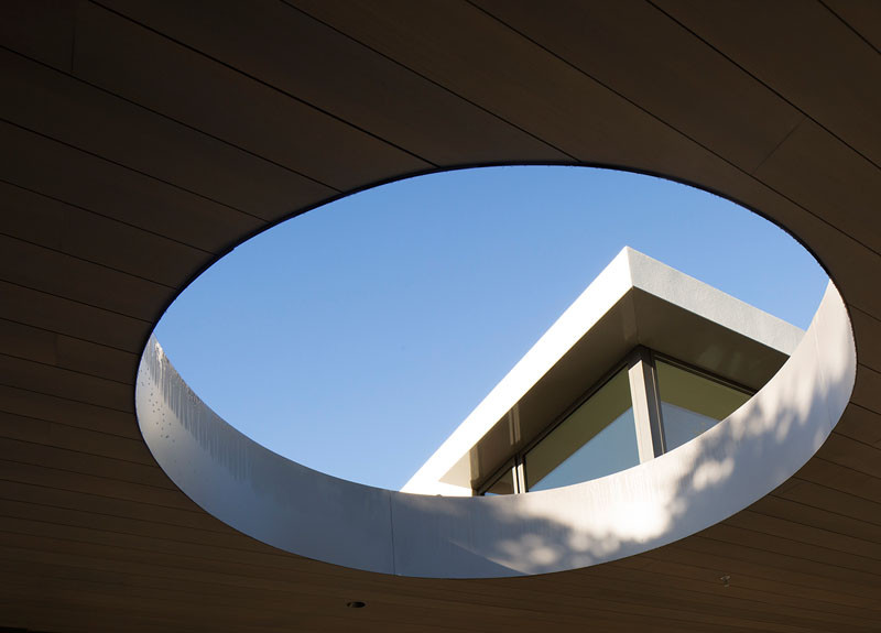 A circular opening creates a view of the sky, and at the same time, creates a distinct shadow on the grass below.