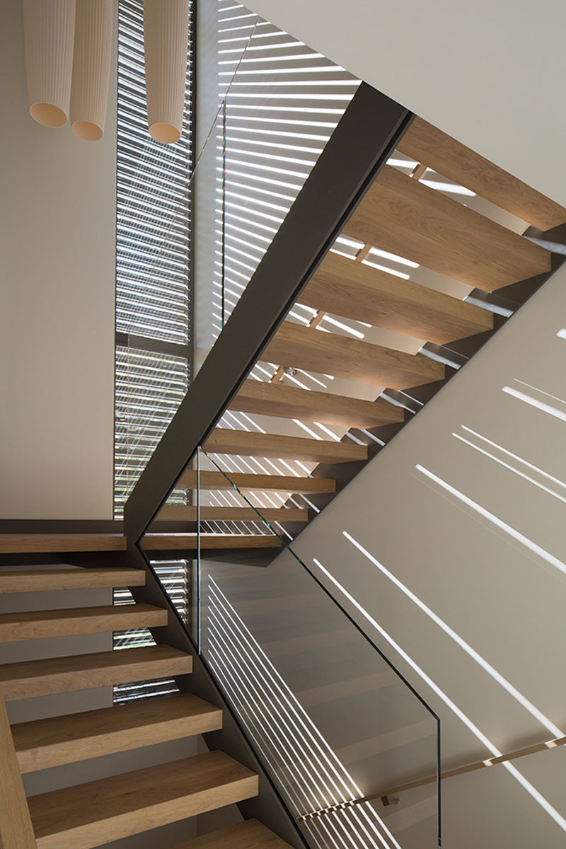 This slender screen runs the height of the front stairwell, that casts rays of sunlight inside during the day. #Stairs #Screen #ModernStairs