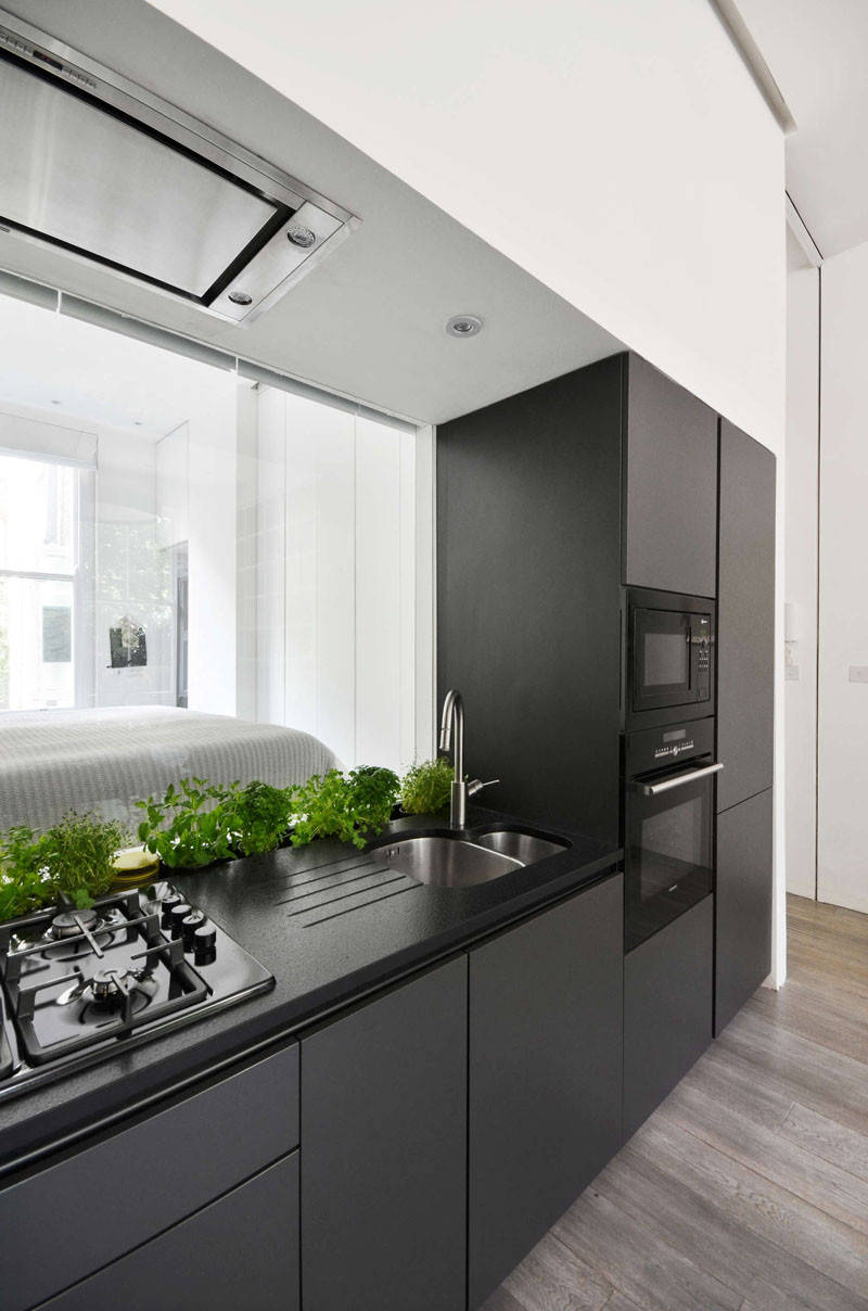 Here's something we don't see too often (if ever). In the kitchen, they have included a glass window backsplash behind the sink, that provides a view through to the bedroom.