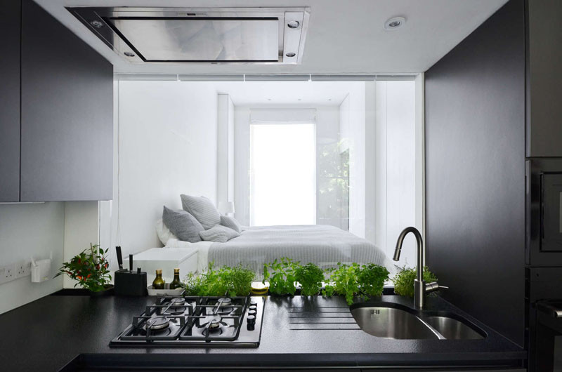 Here's something we don't see too often (if ever). In the kitchen, they have included a glass window backsplash behind the sink, that provides a view through to the bedroom.