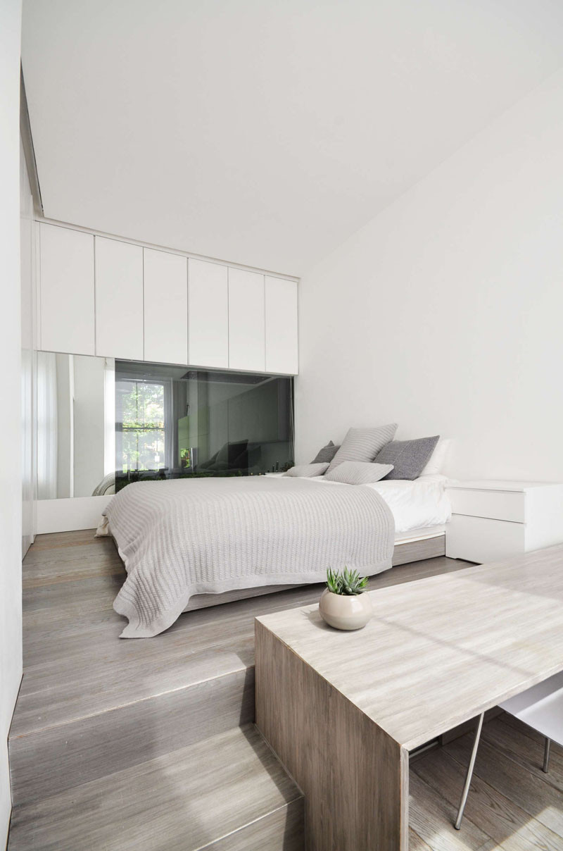 The bed in this bedroom has been raised up to provide a separation from the desk area below