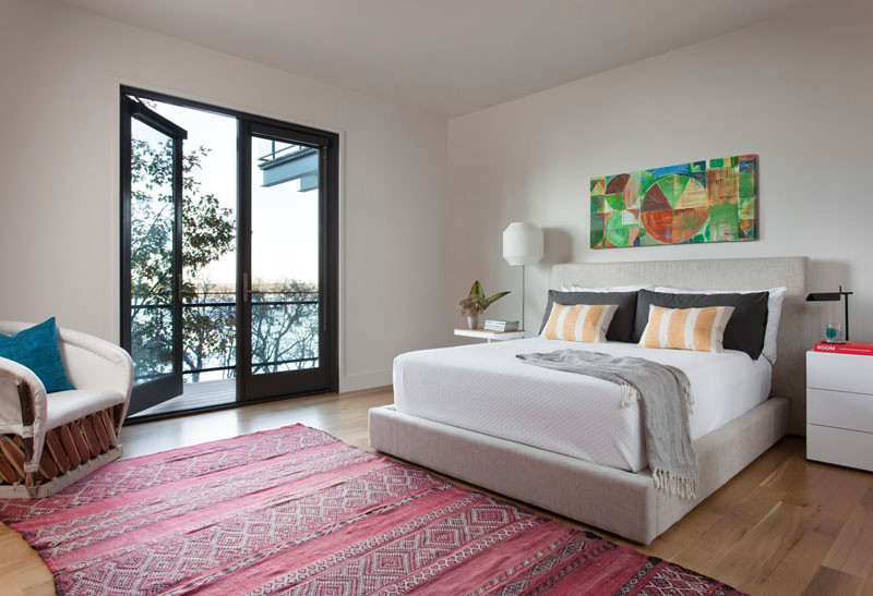 A bright pink rug adds some colour to this bedroom in a home in Texas. // Blue Lake Retreat by Lake|Flato Architects