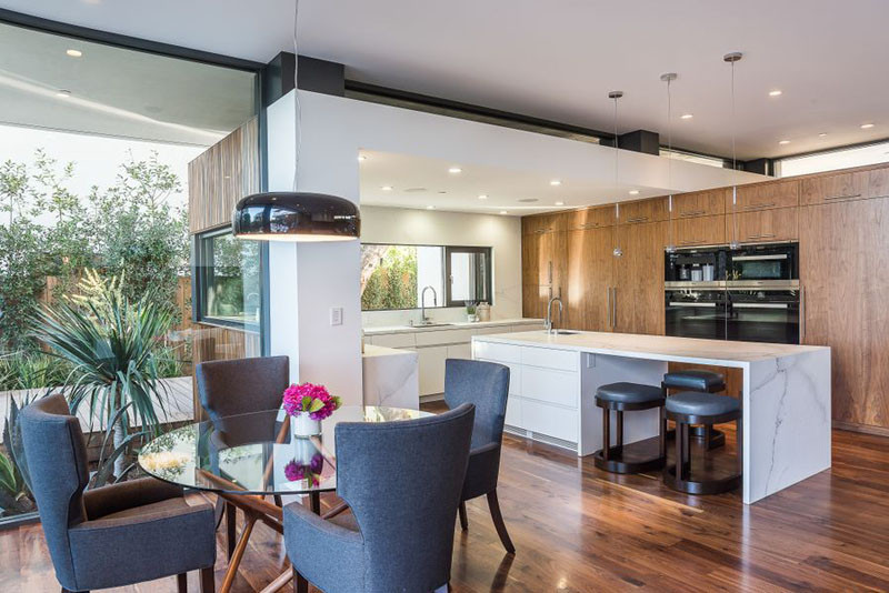 This kitchen has a long kitchen island with stool seating, and a smaller casual dining area right beside it.